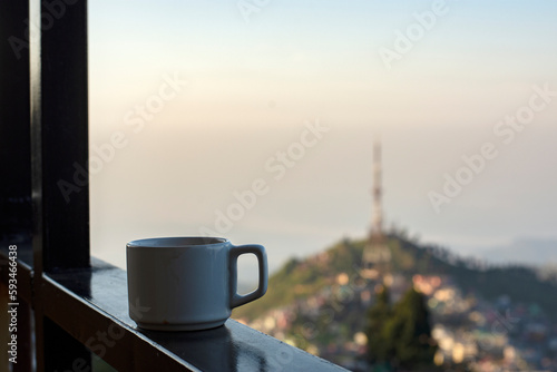 A cup of tea with background beautiful eastern Himalayan hill city Kurseong near Darjeeling, West Bengal India, View of Kurseong town.