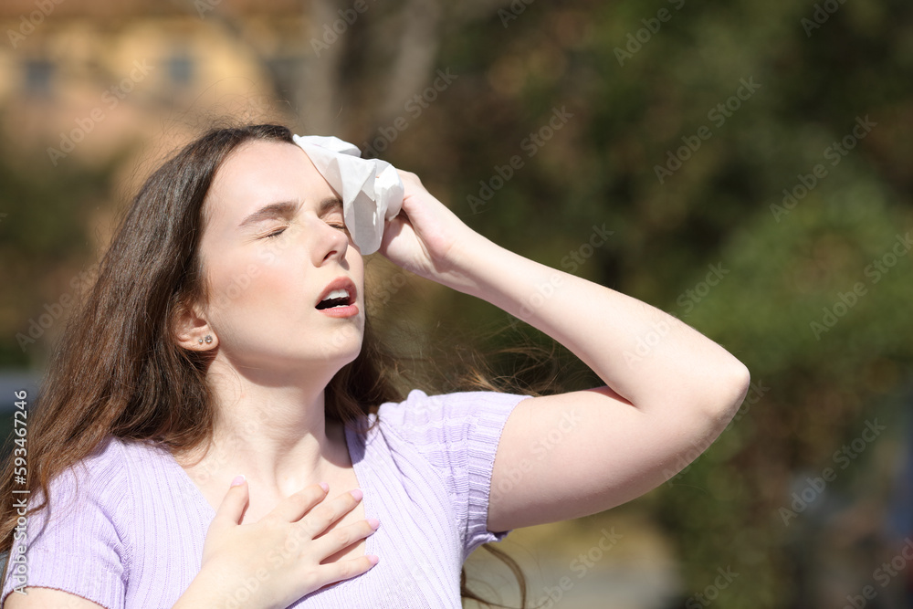 Stressed woman sweating in a park in summer