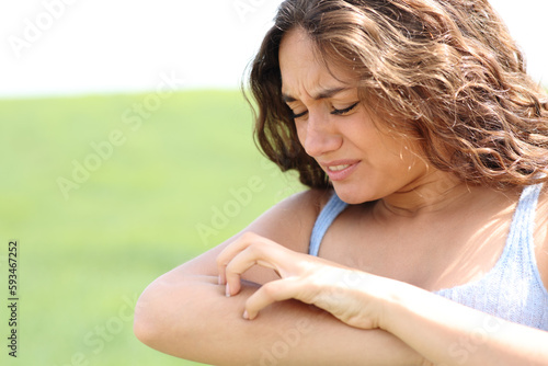 Woman scratching arm in a field photo