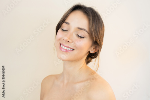 Happy Young Woman With Bright, Glowy and Healthy Skin Smiling with Eyes Closed Feeling Happy and Relaxed