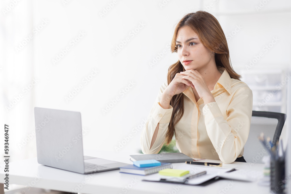 Asian Business woman using calculator and laptop for doing math finance on an office desk, tax, report, accounting, statistics, and analytical research concept
