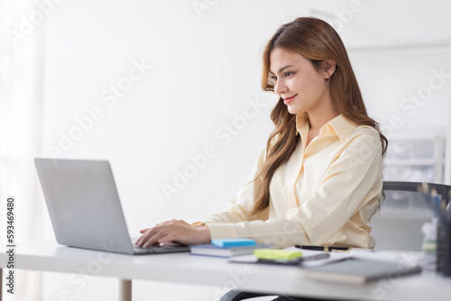 Asian Business woman using calculator and laptop for doing math finance on an office desk, tax, report, accounting, statistics, and analytical research concept 