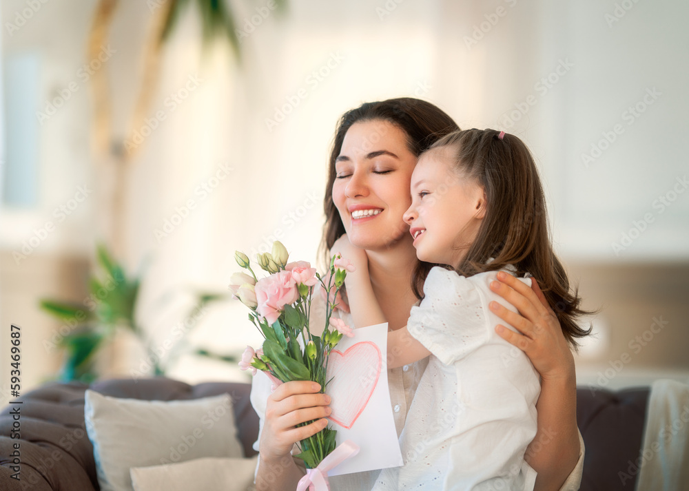 Daughter giving mother bouquet of flowers.