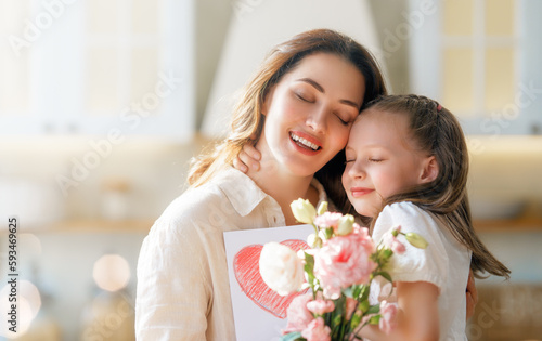 Daughters giving mother bouquet of flowers.