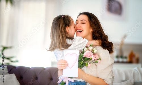 Daughter giving mother bouquet of flowers.