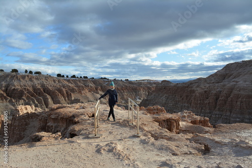 woman in the Cathedral Gorge State Park on a cold day in December, located in a long, narrow valley in southeastern Nevada, where erosion has carved patterns in bentonite clay photo