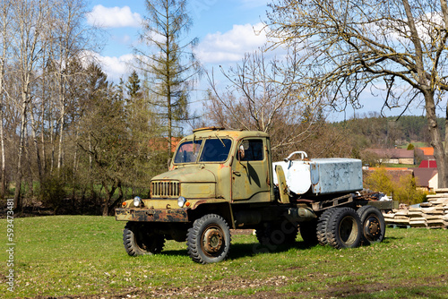 Old truck parked in a farm field along the roadside.