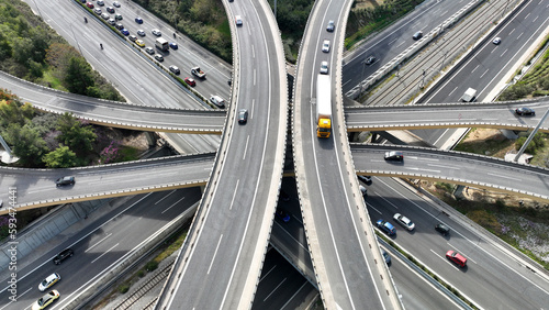 Aerial drone top down photo of multilevel bridge highway road interchange passing near urban residential area during rush hour