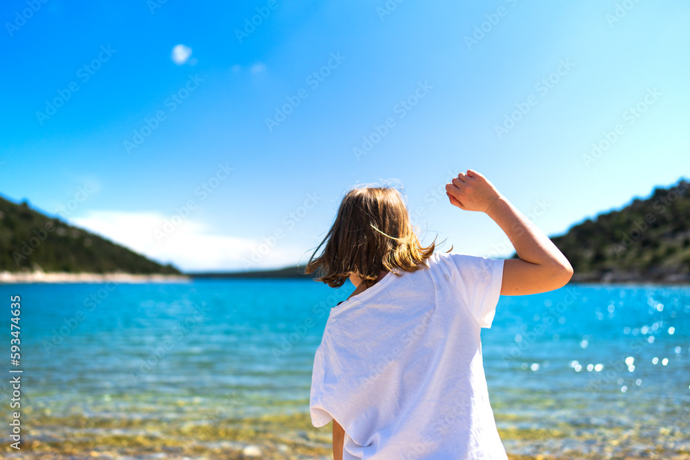 Blondes Kind spielt am Strand in Kroatien im Urlaub und freut sich auf das Wasser Blondes Kind spielt am Strand in Kroatien im Urlaub und freut sich auf das Wasser