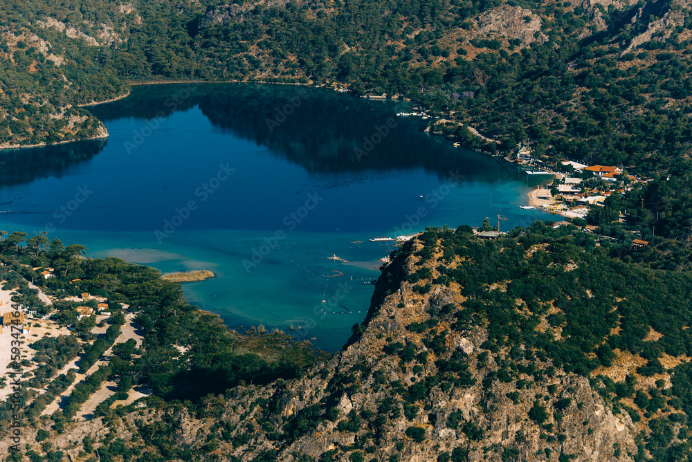 Obraz premium Amazing view of Blue Lagoon in beach resort in the Fethiye district - Oludeniz. Turkey. Summer landscape with mountains, green forest, turquoise coast in bright sunny day. Travel background.