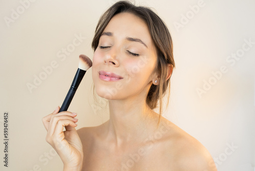 Woman Applying Makeup with Makeup Brush and a No-Makeup Makeup Look with Glowy and Healthy Skin Perfect Complexion Blush Contouring