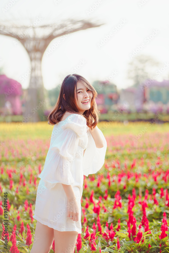 Portrait of young beautiful Asia woman model posing in spring or summer red flower field blooming in garden. pretty girl happy in white dress clothing. Portrait of young beautiful Asia woman model posing in spring or summer red flower field blooming in garden. pretty girl happy in white dress clothing.