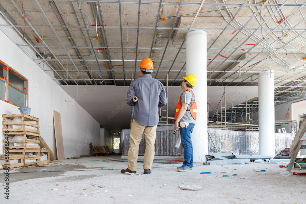 Fototapeta premium Construction concept of Engineer and Architect working with construction model and blueprint at construction site, Engineer and Architect discussing construction plan at building site