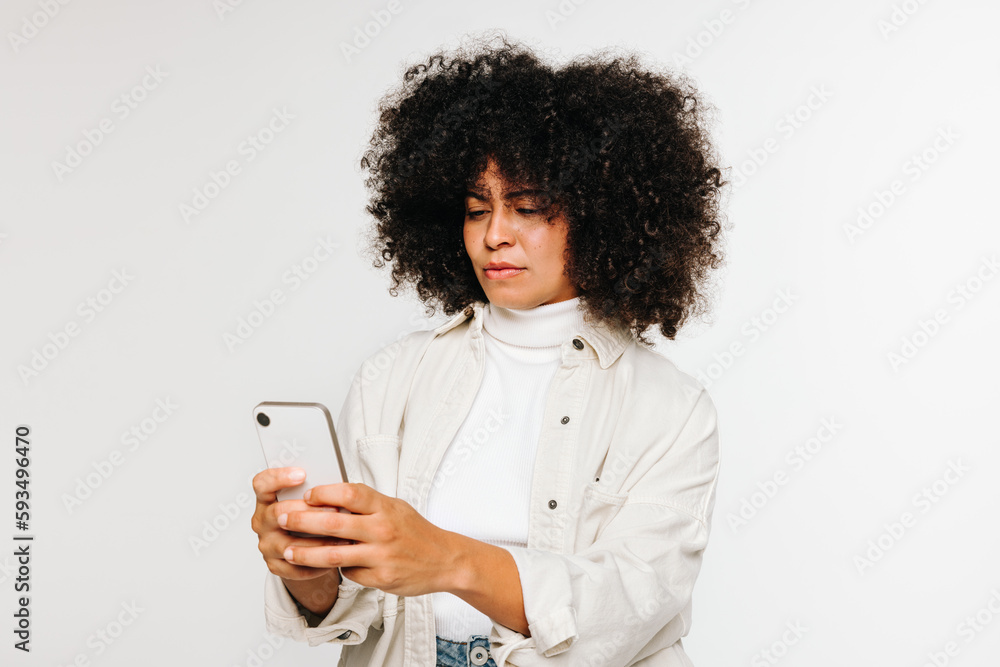 Young woman using a smartphone against a white background Young woman using a smartphone against a white background