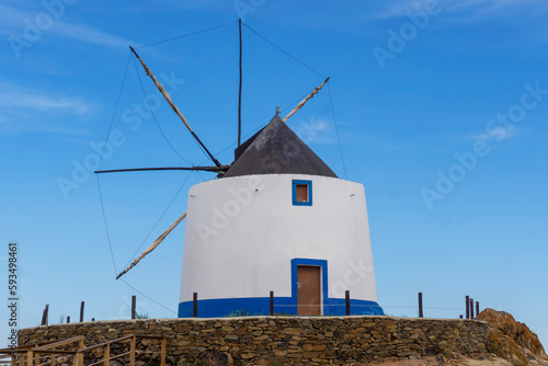 Old restored windmill in Aljezur, Portugal, against of the blue sky 