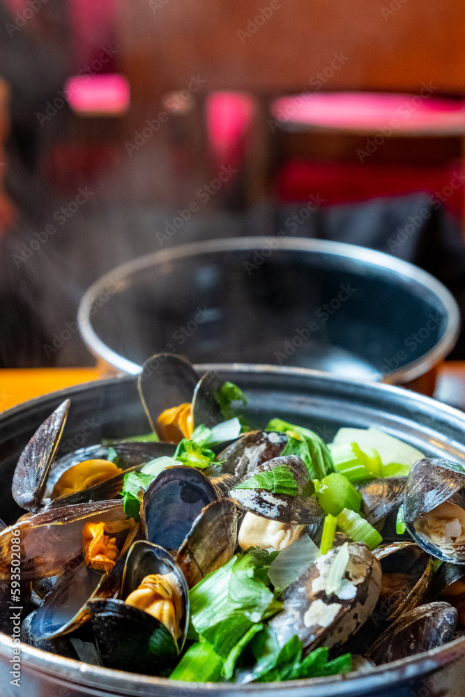 A closeup of a delicious steamed mussel casserole in a Belgian restaurant. A closeup of a delicious steamed mussel casserole in a Belgian restaurant.