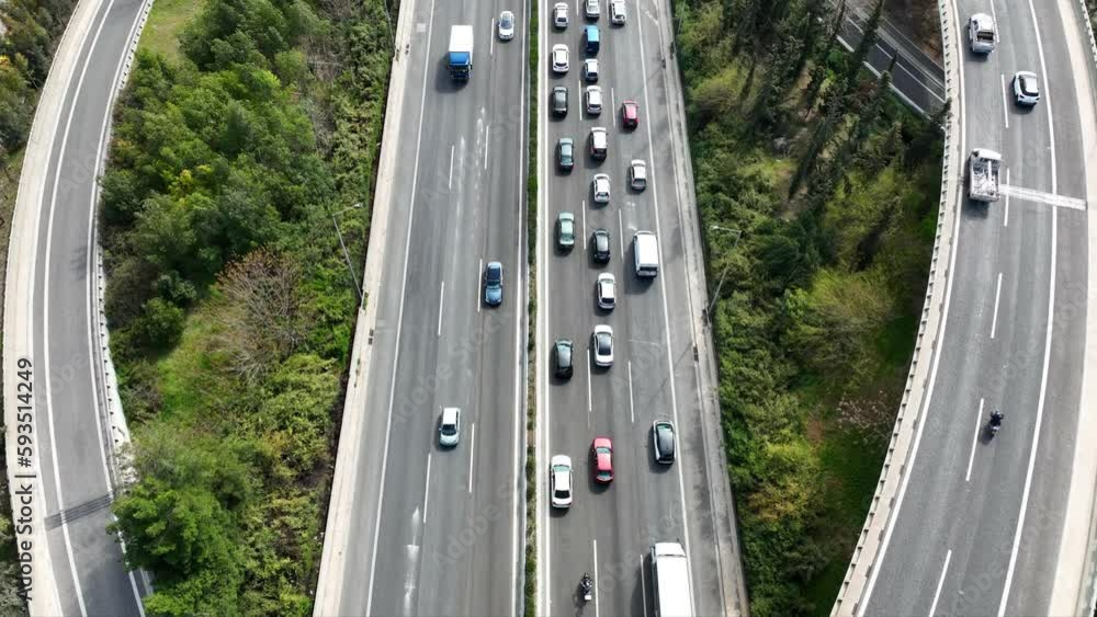 Aerial drone top down video of highway road during rush hour passing near urban residential area Aerial drone top down video of highway road during rush hour passing near urban residential area
