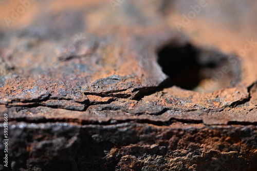 A hole in a heavy, rusty metal plate.