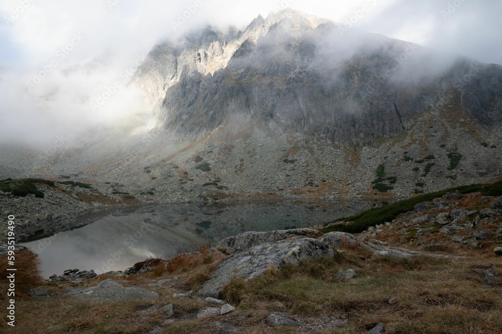 Clean, tranquil lake on top of the mountain surrounded by massive rocks and stones Clean, tranquil lake on top of the mountain surrounded by massive rocks and stones