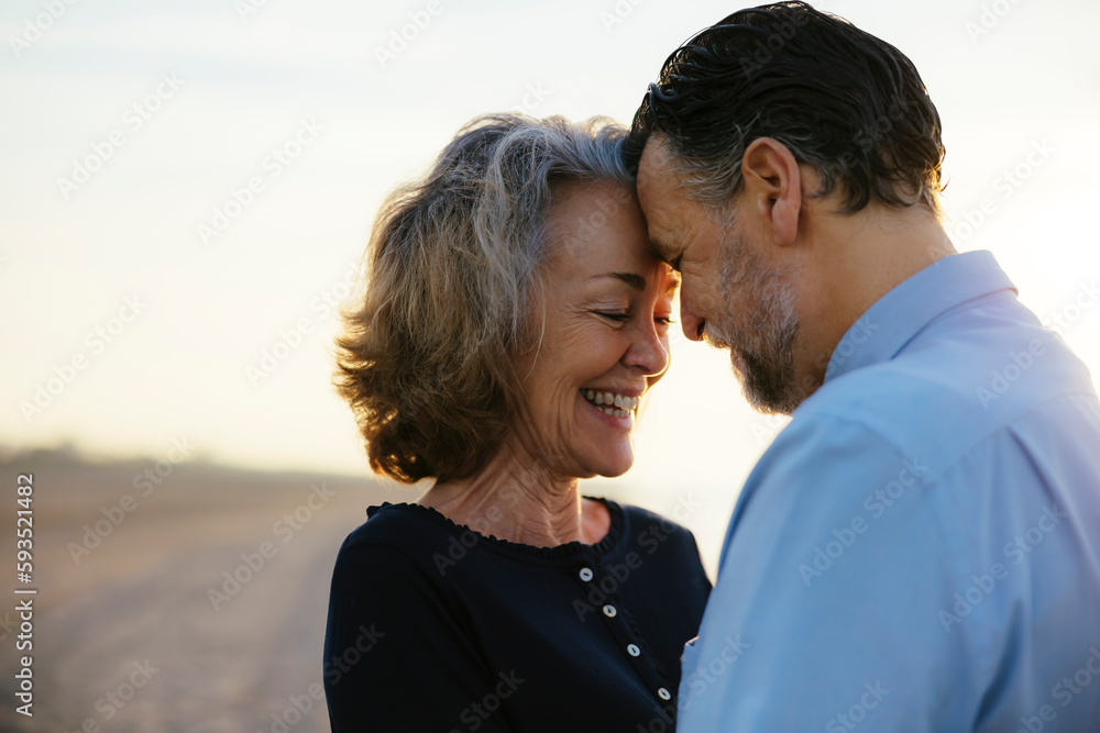 Happy mature couple enjoying and embracing each other at beach Happy mature couple enjoying and embracing each other at beach