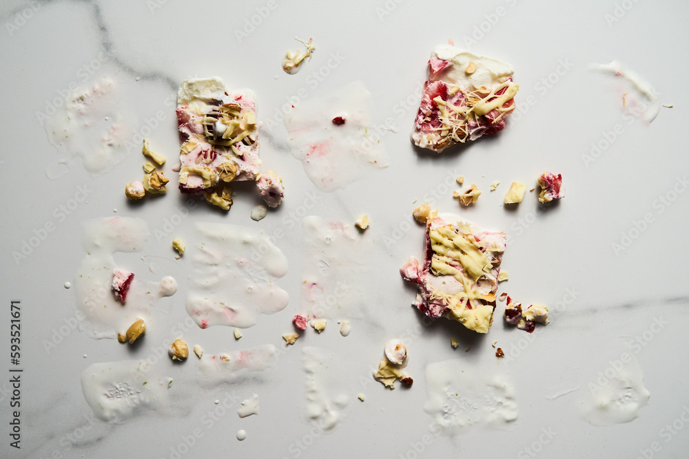 Healthy Frozen Greek Yogurt bars with strawberry with lime zest, nuts and white chocolate. Homemade sweet dessert. Mess and dirty after it melted Healthy Frozen Greek Yogurt bars with strawberry with lime zest, nuts and white chocolate. Homemade sweet dessert. Mess and dirty after it melted