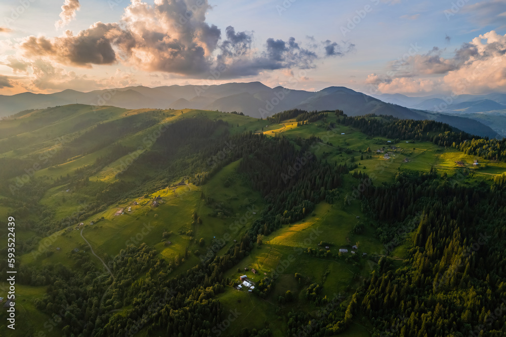 Amazing morning fog in the mountains. Beautiful sunrise light shines on the red beech forest. Drone panorama.