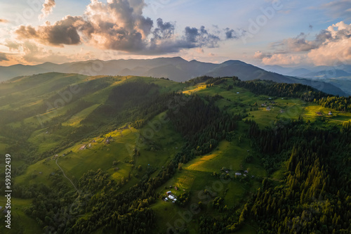 Amazing morning fog in the mountains. Beautiful sunrise light shines on the red beech forest. Drone panorama.