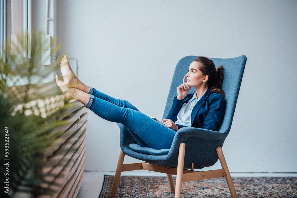 Thoughtful young businesswoman sitting on armchair Thoughtful young businesswoman sitting on armchair