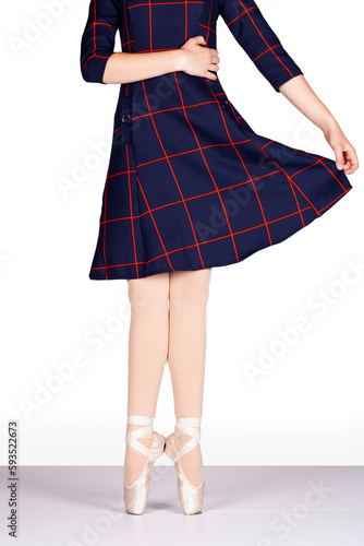 En Pointe CORRECT heels together hand on waist and holding blue tartan dress out teacher perspective Young female ballet dancer pink silk and satin pointe shoes Reference for teacher and student photo