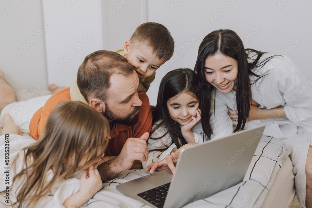 Happy family using laptop in bedroom at home Happy family using laptop in bedroom at home