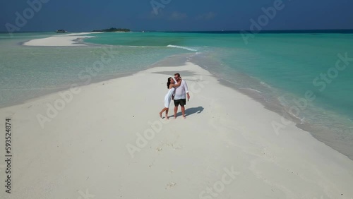 Aerial view of happy couple in love in white clothes spending great time together on Maldives photo