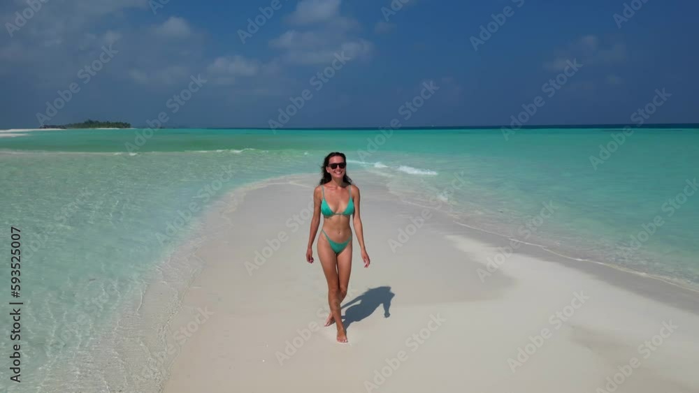 young woman tanning sunbathing woman wearing bikini at the beach on a white sand from above view from drone young woman tanning sunbathing woman wearing bikini at the beach on a white sand from above view from drone