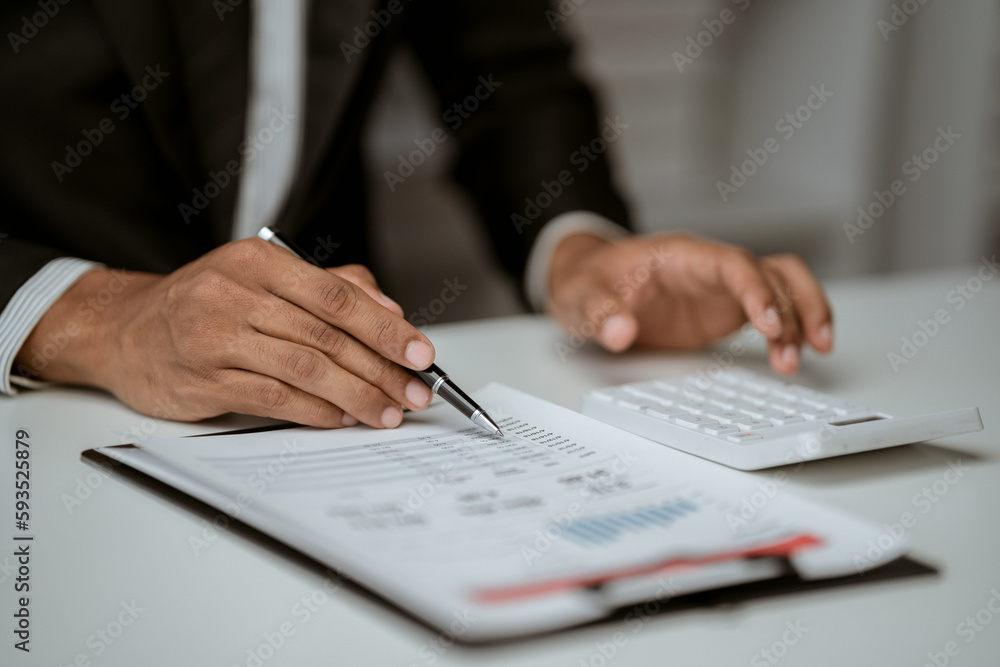 businessman working on desk office with using a calculator to calculate the numbers, finance accounting concept businessman working on desk office with using a calculator to calculate the numbers, finance accounting concept