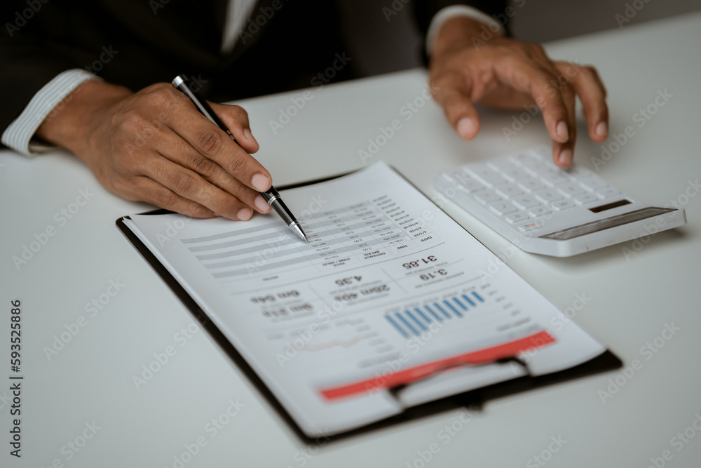 businessman working on desk office with using a calculator to calculate the numbers, finance accounting concept businessman working on desk office with using a calculator to calculate the numbers, finance accounting concept