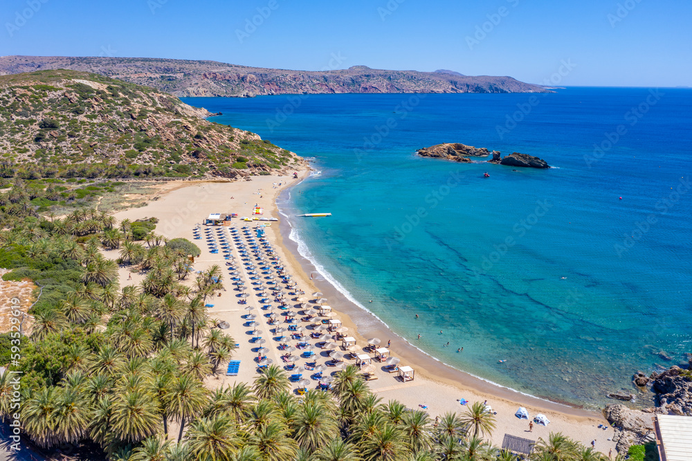 Palm Vai Beach, Crete, Greece - beautiful drone aerial view of palm forest, blue water, sky and sun shelters