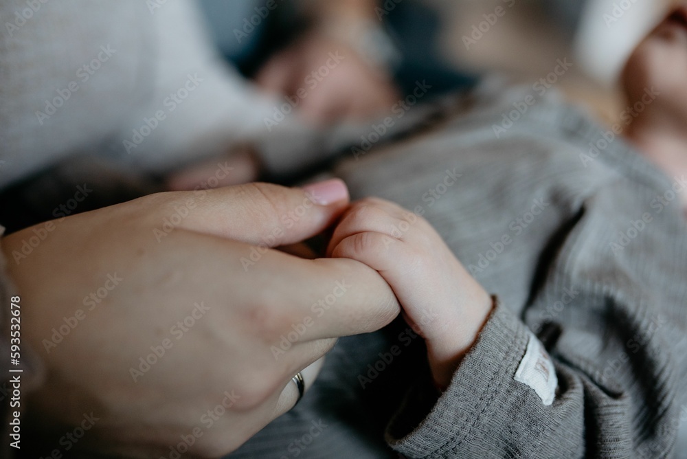 Fototapeta premium Closeup shot of the mother holding the hand of the newborn baby