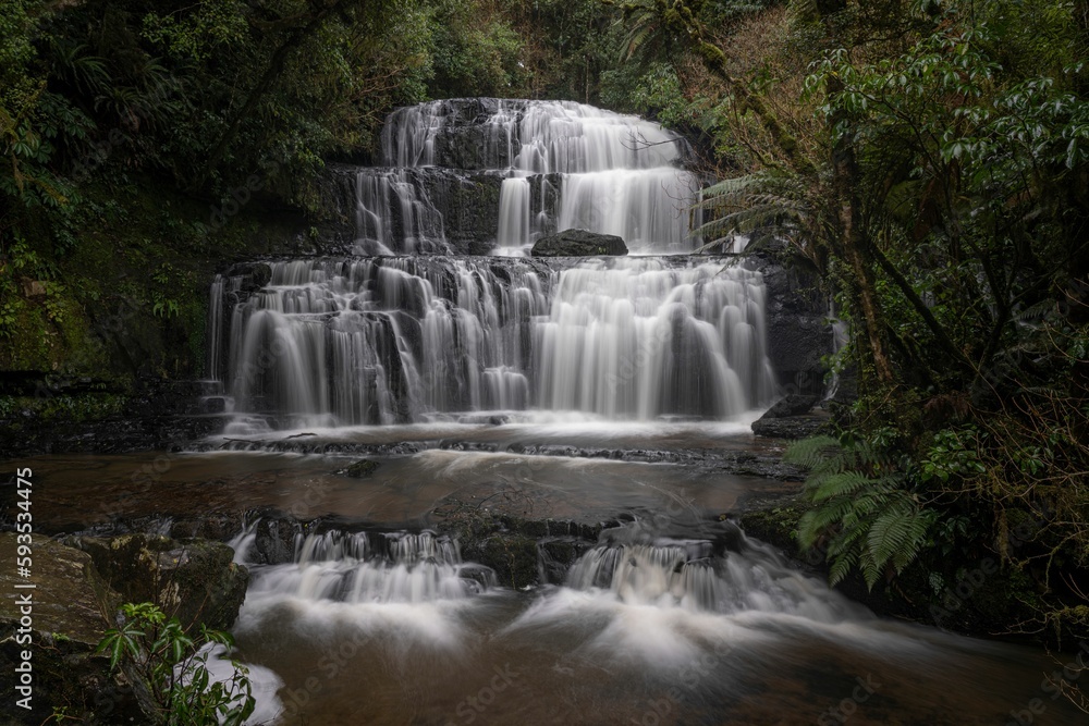 Waterfall on a foggy mountain to the river in New Zealand. Waterfall on a foggy mountain to the river in New Zealand.