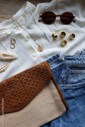 White blouse, denim skirt, vintage bag, sunglasses, pearl barrettes and gold jewelry. Top view.