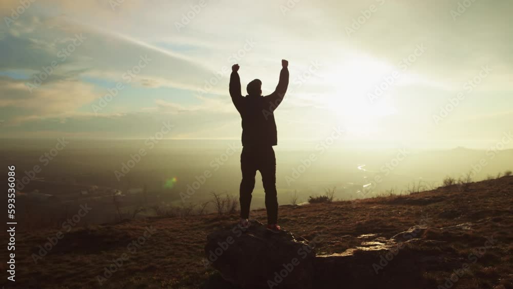 One Successful Happy Travel Man Standing Top Joy and Raises Hands Up. Joyful Silhouette Man Looking at View Sunset Sky Behind Mountains. Adventure Traveling Hike Man Hands Raised on Hill, slow motion One Successful Happy Travel Man Standing Top Joy and Raises Hands Up. Joyful Silhouette Man Looking at View Sunset Sky Behind Mountains. Adventure Traveling Hike Man Hands Raised on Hill, slow motion
