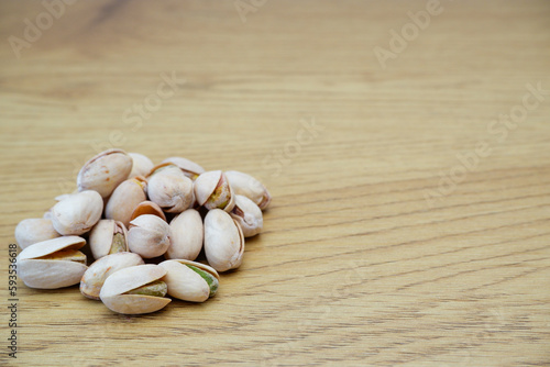 Pistachio nuts on a wooden table. Pistachios background close-up  place for text.