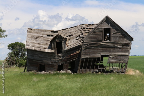 Outdoor rural scene of an old, weathered and abandoned wooden farm house.