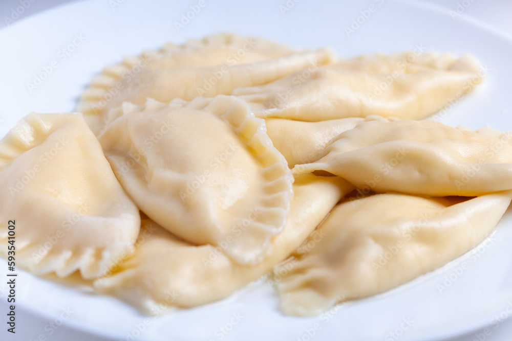 Boiled dumplings with cheese inside on a white plate. Vareniki Boiled dumplings with cheese inside on a white plate. Vareniki
