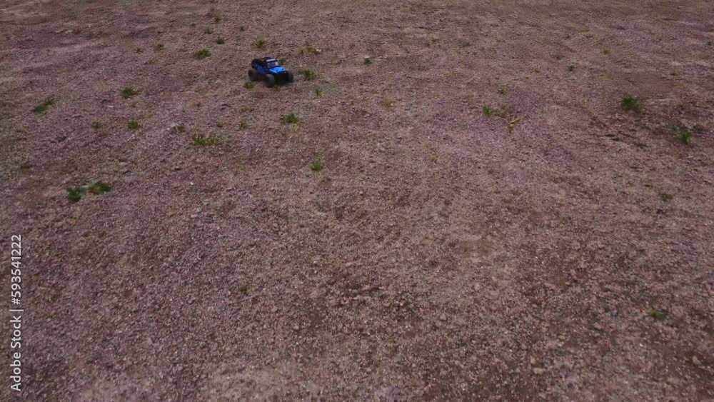 A 4x4 Jeep toy truck drives fast, approaching from a leading shot and over rough terrain as seen from high aerial angle. Followed by an RC drone, the car flies away across the floor of soil. A 4x4 Jeep toy truck drives fast, approaching from a leading shot and over rough terrain as seen from high aerial angle. Followed by an RC drone, the car flies away across the floor of soil.
