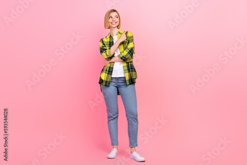 Full size photo of pretty young girl finger point empty space dressed stylish checkered yellow outfit isolated on pink color background