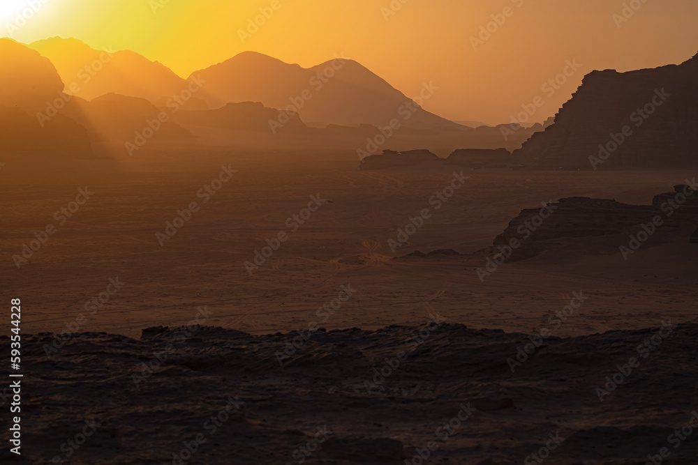 Wadi Rum w Jordanii. Słońce zachodzące za pustynne góry. 