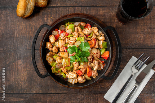 Sauteed chicken with pepper in a cast iron pan