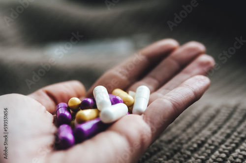hands of a person with a lot of pills