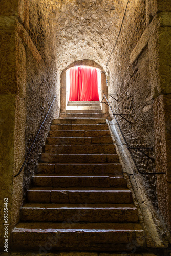 Old corridor with red curtain at the end. Concept for mystery, gothic, escape, hope. © Paolo Gallo