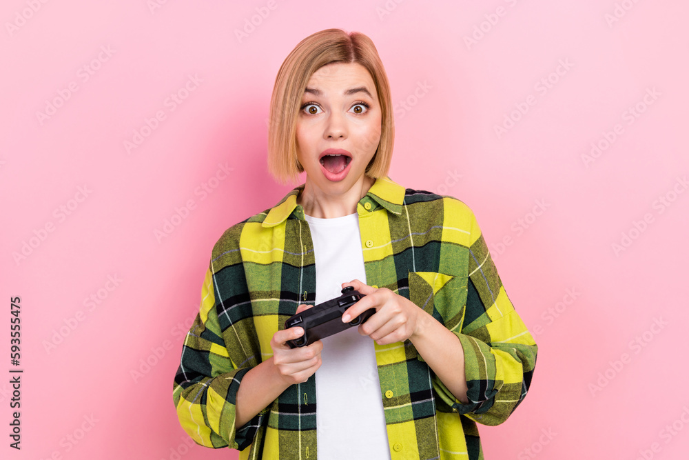 Photo of astonished positive girl hands hold controller play video games isolated on pink color background Photo of astonished positive girl hands hold controller play video games isolated on pink color background