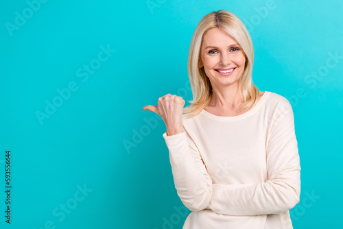 Photo of cheerful charming woman wear white shirt showing thumb empty space isolated turquoise color background